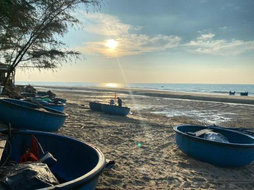 a group of boats sitting on the beach at Homestay Bằng Lăng Tím - Bình Thuận in Hàm Tân