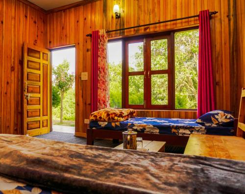 um quarto com 2 camas e uma grande janela em Pine Valley Homestay em Nainital