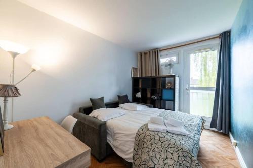 une chambre avec un lit, une table et une fenêtre dans l'établissement Agréable Appart face au métro - Parking gratuit, à Lambersart