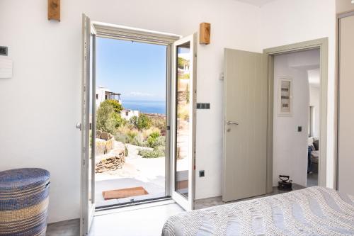 a bedroom with a door open to a view of the ocean at Black Tower Villa in Apollonia