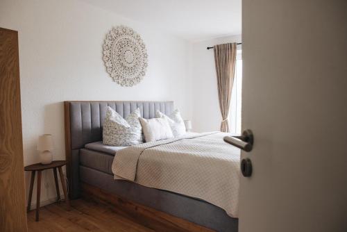 a bedroom with a bed with white pillows and a window at Ferienanlage Villa Maare in Gillenfeld