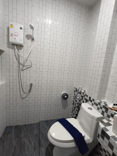 a bathroom with a toilet with a blue towel on it at Hello Montri in Klong Muang Beach