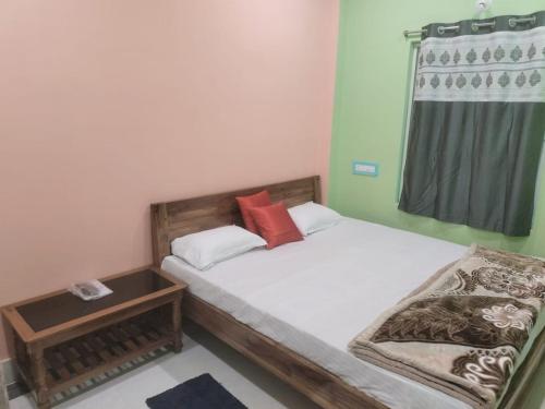 um pequeno quarto com 2 camas e uma janela em Maruti Guest House em Puri