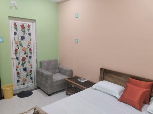 um quarto com uma cama, uma cadeira e uma janela em Maruti Guest House em Puri