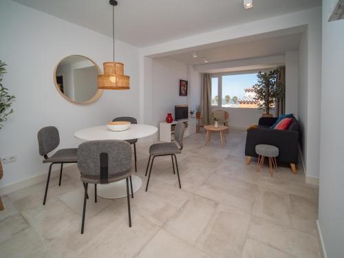 a dining room and living room with a table and chairs at Sibs Sanlúcar Atlantico Playa Vistas Reformado in Sanlúcar de Barrameda