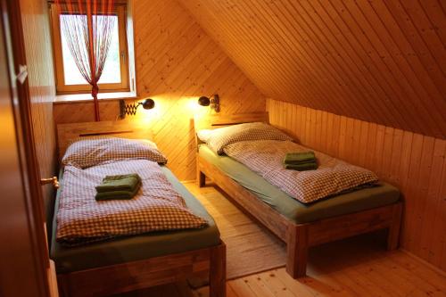 a room with two beds in a wooden house at Ferienwohnung Zum alten Forsthaus in Messern