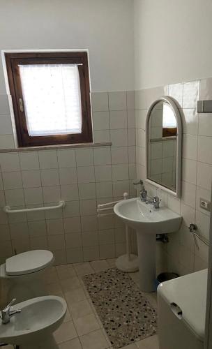 a bathroom with two toilets and a sink and a mirror at B&B Villa Rosina in Satriano di Lucania