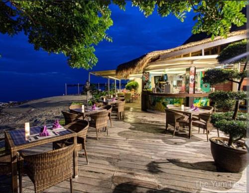 a restaurant on the beach with tables and chairs at Villa Medina @ Sepang Gold Coast in Bagan Lalang