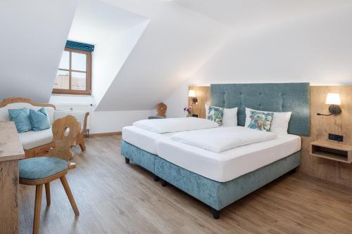 a bedroom with a large bed and a chair at Hotel Obermaier in Munich