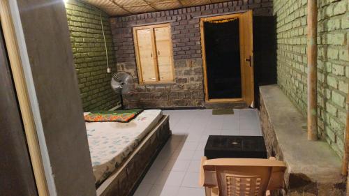 a room with a bed and a table and a door at Taste Of Hampi - Stay @ Nature in Hampi