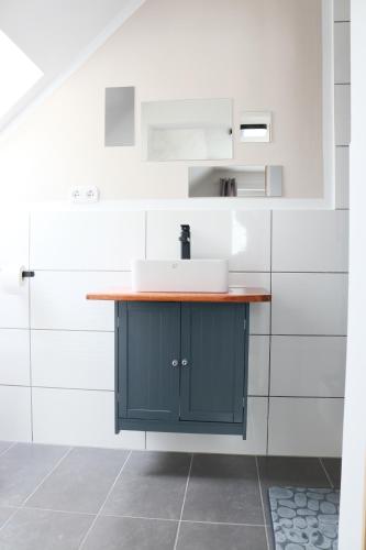 ein Bad mit einem Waschbecken und weißen Wänden in der Unterkunft KS Home in Augsburg