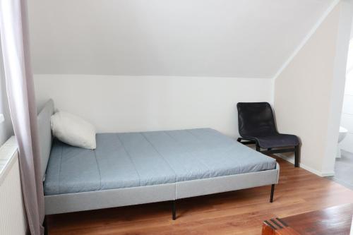 ein Bett und ein Stuhl in einem Zimmer in der Unterkunft KS Home in Augsburg