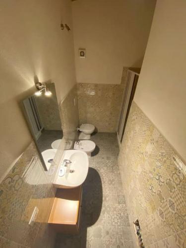 a bathroom with two sinks and a toilet at Pettirosso 6 in San Teodoro