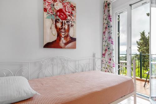 a bedroom with a bed with a painting on the wall at Monte Verde Apartment 102 in Dhematorá