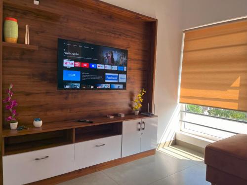 salon z telewizorem z płaskim ekranem na ścianie w obiekcie CuteHug Home stay w mieście Kalpatta