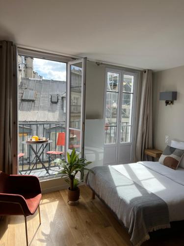 une chambre avec un lit et une grande fenêtre dans l'établissement Quartierlatin apartment, à Paris