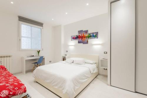 a white bedroom with a bed and a desk at RomeEyes2020 in Rome