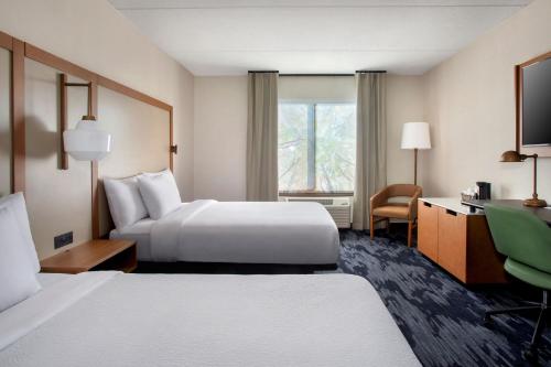 a hotel room with two beds and a window at Fairfield by Marriott Rochester Henrietta/University Area in Henrietta