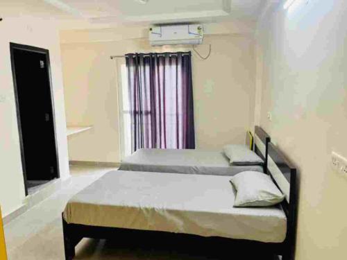 Stay In Hotels and Resorts في حيدر أباد: غرفة نوم بسريرين ونافذة
