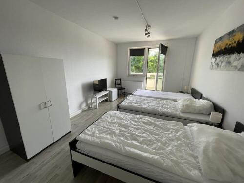 a bedroom with two beds and a window at Am Ring Monteurzimmer Apartment Böhlen in Böhlen