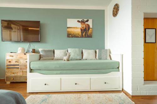 - une chambre avec un lit avec une vache sur le mur dans l'établissement Appartement Honey, à Sankt Englmar