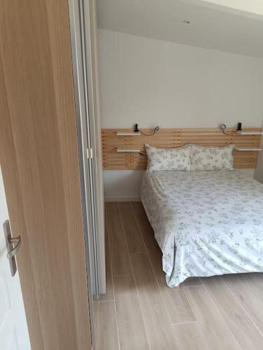 une chambre avec un lit avec une tête de lit en bois dans l'établissement Maison proche Paris., à Saint-Denis