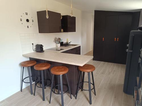 a kitchen with a counter and some stools at Maison proche Paris. in Saint-Denis