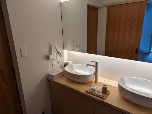 een badkamer met 2 wastafels en een spiegel bij ECHO in Yonezawa