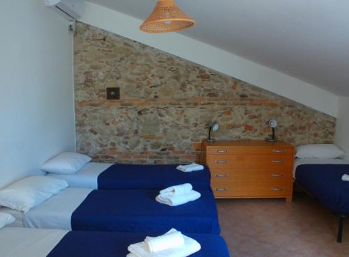 1 dormitorio con 2 camas y pared de piedra en Oasi del Governatore en Squillace