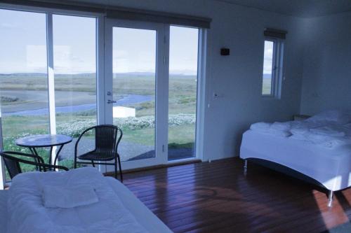 um quarto com uma cama, uma mesa e cadeiras em Grímstunga Guesthouse em Víðirhóll