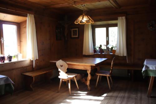 ein Esszimmer mit einem Holztisch und 2 Stühlen in der Unterkunft mösslerhof in Aldino