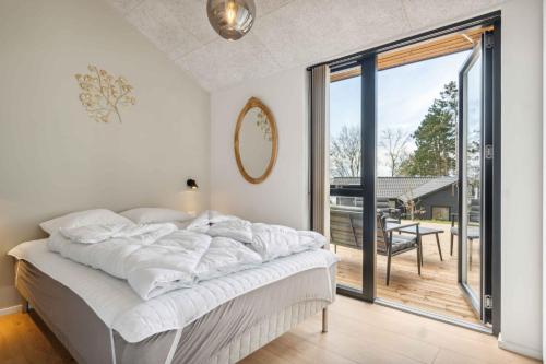 - une chambre blanche avec un lit et un balcon dans l'établissement Impressive Holiday Cottage, By The Helsns Bay!, à Millinge