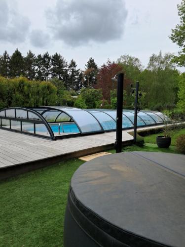 un pont avec une piscine dans un parc dans l'établissement le buisson de la gariole ,chambre rhétaise, à Aubigny-sur-Nère