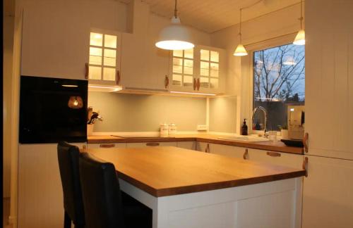 a kitchen with a wooden counter top and a refrigerator at Lovely Summer House In Tranquil Nature, in Ebeltoft