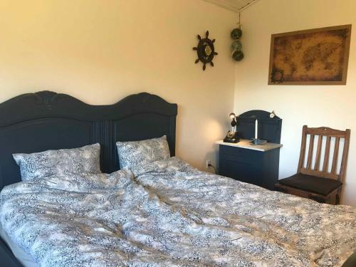 - une chambre avec un grand lit et une chaise dans l'établissement Super Nice House In The Harbor Town Of Hvalpsund,, à Farsø