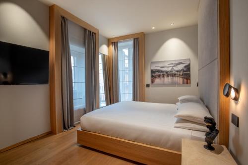 una camera da letto con un grande letto bianco e finestre di Ripetta Luxury Apartments a Roma