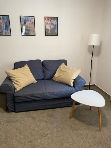 a living room with a blue couch and a table at Penzion Pivovar 66 in Česká Lípa