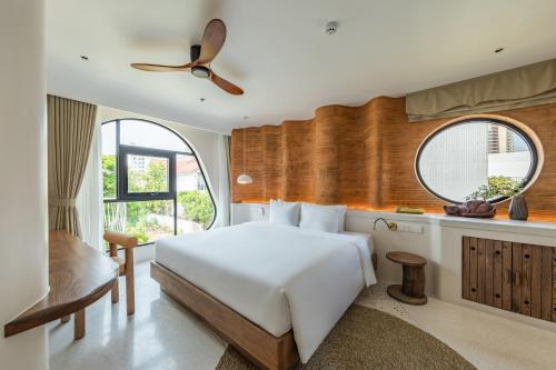 a bedroom with a white bed and a ceiling fan at Saha Casa Boutique Hotel Da Nang in Da Nang