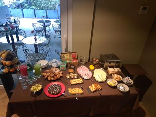 a table with a bunch of food on it at BHL Boutique Rooms Legnano in Legnano