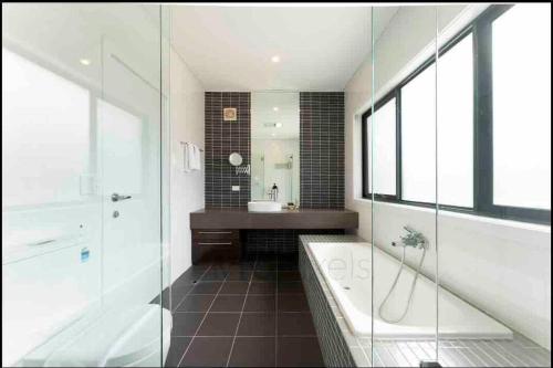 a bathroom with a shower and a tub and a sink at Sunset Bay#5 bed Family house Sailing Panorama in Sydney