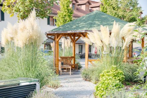 a wooden gazebo with a bench in a garden at Hotel Obermaier in Munich