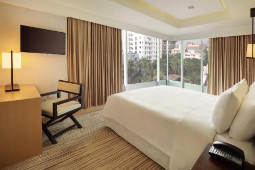 a hotel room with a bed and a desk and a window at Crowne Plaza Dhaka Gulshan by IHG in Dhaka