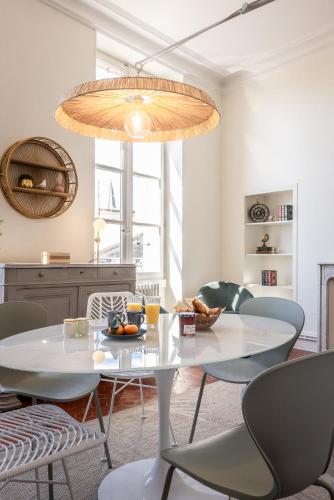 une salle à manger avec une table et des chaises blanches dans l'établissement Avignon Intra-muros, vue Palais des Papes, à Avignon