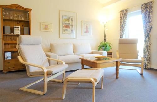 una sala de estar con un sofá y dos sillas en Warnemünde Appartement Parkblick REF 81886, en Warnemünde