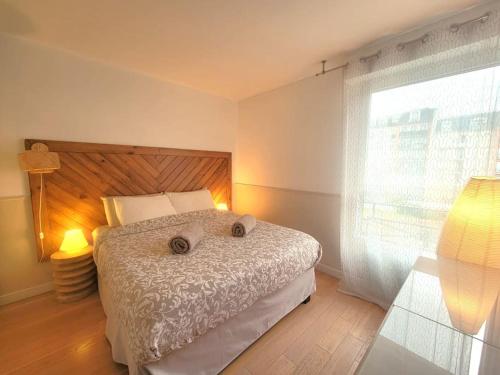 - une chambre avec un lit doté d'une tête de lit en bois et d'une fenêtre dans l'établissement Appartement moderne 2 chambres, à Saint-Maurice