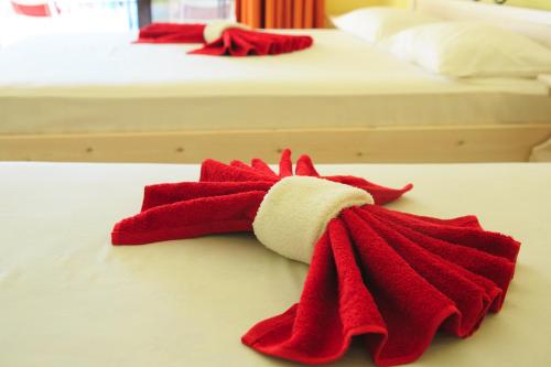 two beds with red and white towels on them at Stroubis Studios I in Megás Limniónas