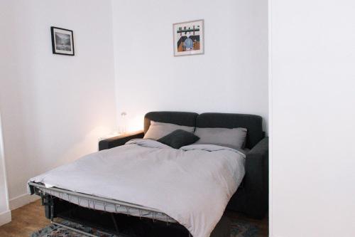 Ce lit se trouve dans un dortoir doté d'un mur blanc. dans l'établissement Charming studio in Paris near the Eiffel Tower, à Paris