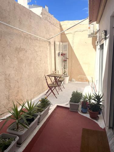 a courtyard with a table and potted plants on a building at Socratous House in Salamís
