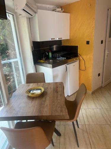 a kitchen with a wooden table and chairs and a kitchen with a stove at Resort Stikovic in Dobra Voda