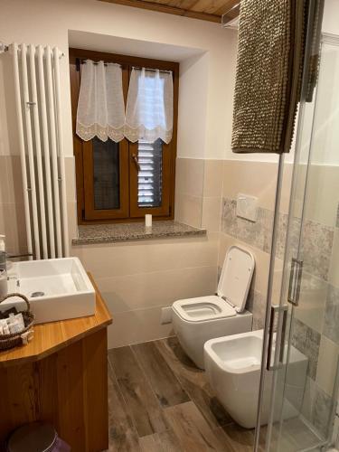 ein Bad mit einem WC und einem Waschbecken in der Unterkunft monolocale incantevole in Sordevolo